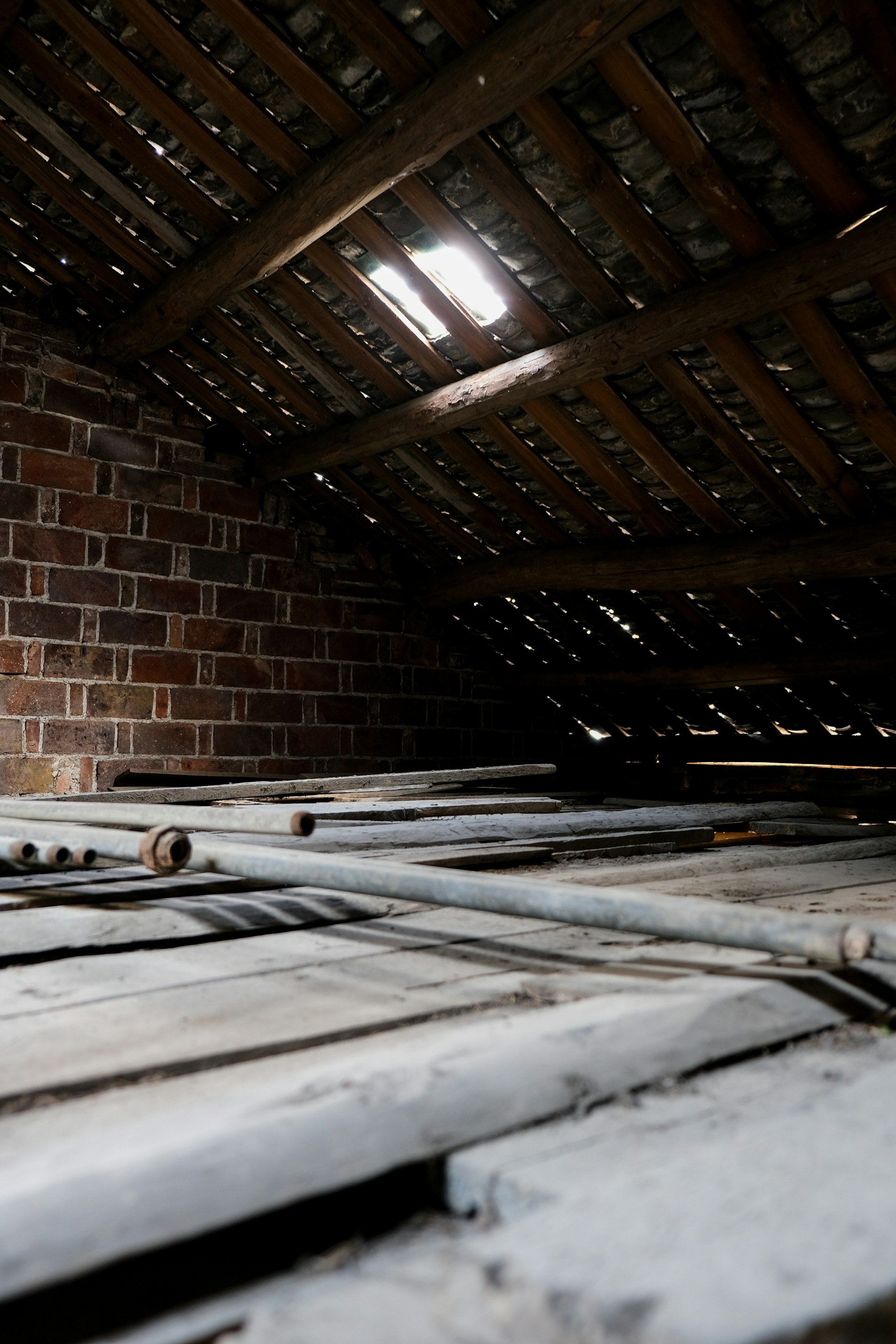 Buhardilla sin aislar: vigas, suelo de madera y muro de ladrillo — pérdidas térmicas por la cubierta (ilustrativa)